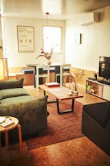 Living Room, Coffee Tables, Table, Cork Floor, Pendant Lighting, Sofa, Chair, Media Cabinet, Rug Floor, and End Tables An Isabel lounge chair by Prísma Studio&nbsp;sits in the foreground. The couple are friends with the designers.